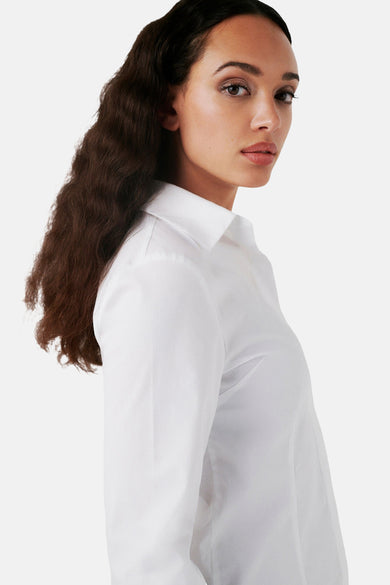 Chemise blanche à manches longues de CAROLL, en coton, avec une femme aux cheveux longs et bruns.