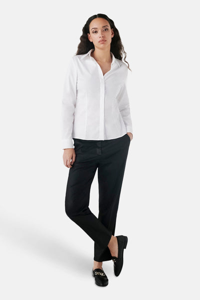 Chemise blanche à manches longues par CAROLL, portée avec un pantalon noir et des mocassins classiques.
