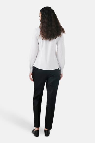 Witte blouse met lange mouwen van CAROLL, gedragen met een zwarte broek, achtergezicht.