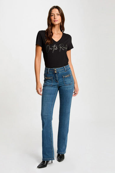 T-shirt noir à manches courtes de Morgan de Toi, porté avec un jean bleu et des escarpins noirs.