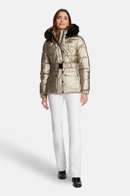 Veste courte dorée de Morgan de Toi avec ceinture et capuche bordée de fourrure, portée avec un jean blanc et des bottines noires.
