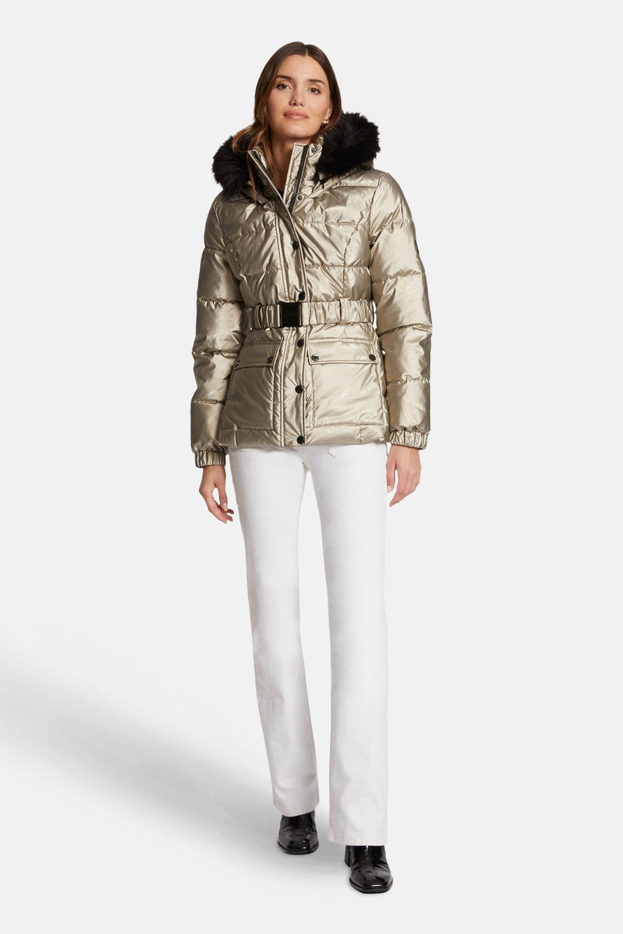 Veste courte dorée de Morgan de Toi avec ceinture et capuche bordée de fourrure, portée avec un jean blanc et des bottines noires.
