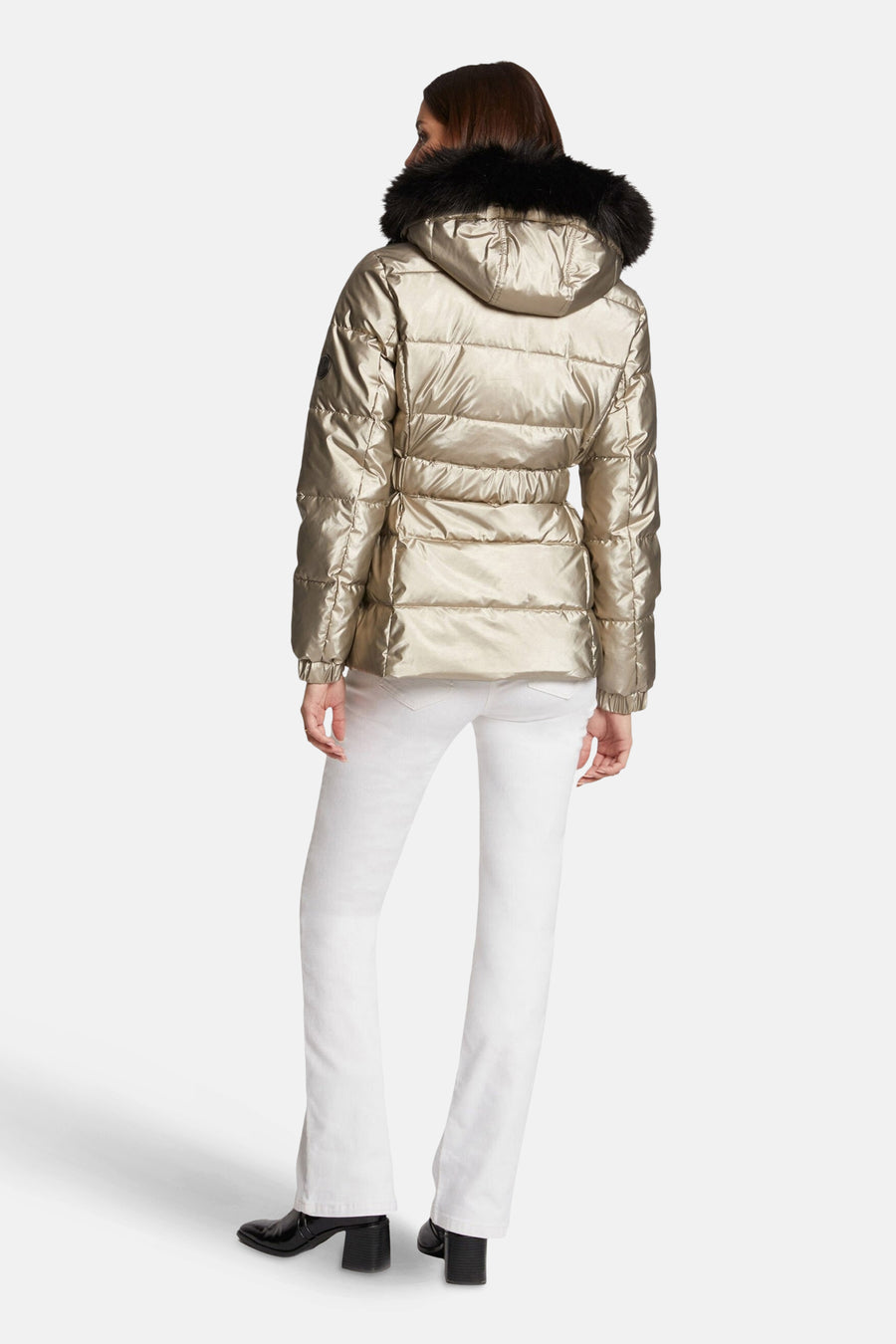 Veste courte dorée de Morgan de Toi avec capuche bordée de fourrure noire, portée avec un jean blanc et des bottines noires.
