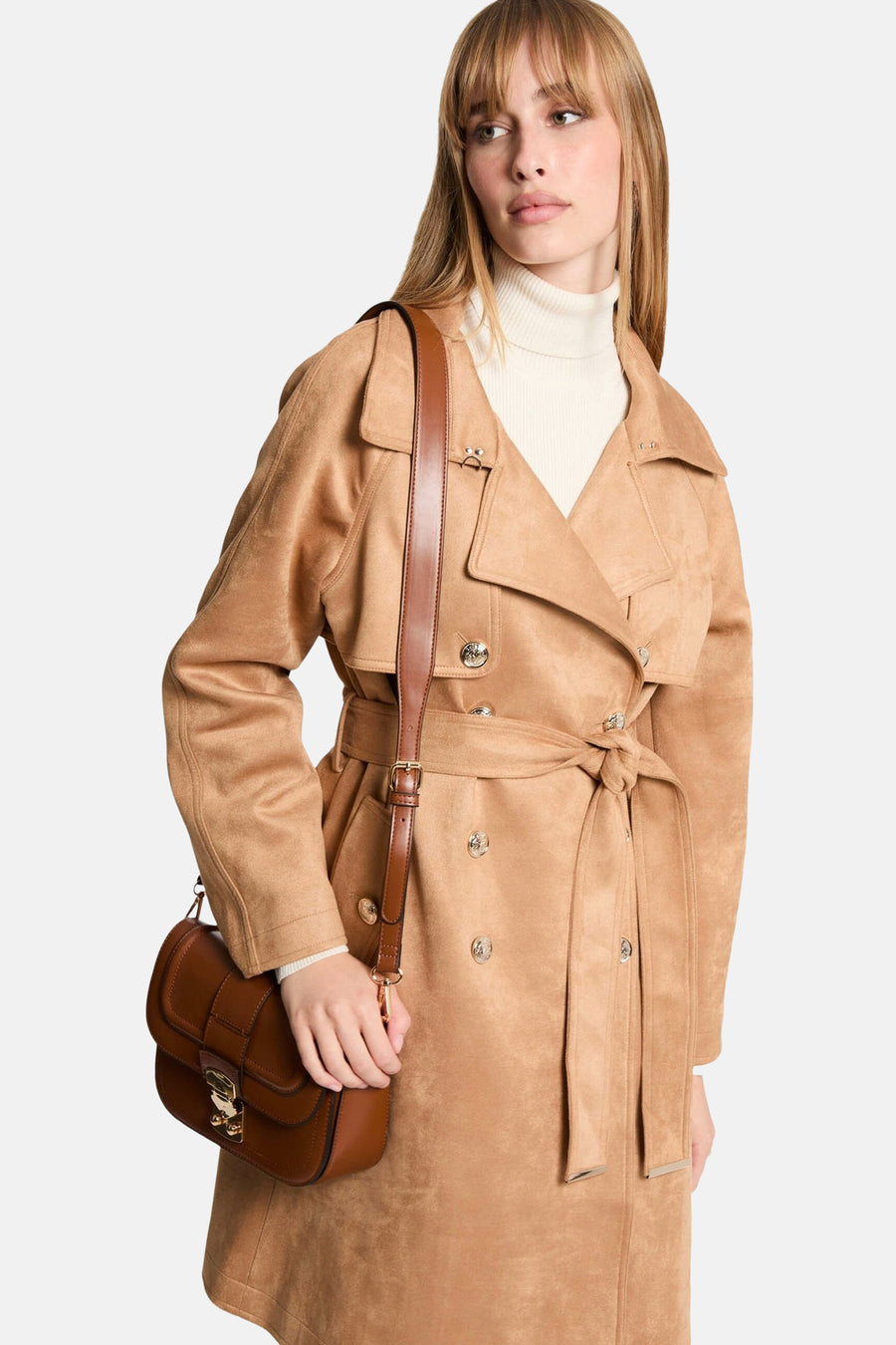 Veste cognac de Morgan de Toi, style trench avec ceinture, portée sur un pull à col roulé.