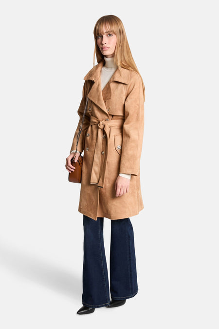 Veste cognac de Morgan de Toi, avec une ceinture nouée et portée sur un jean évasé.
