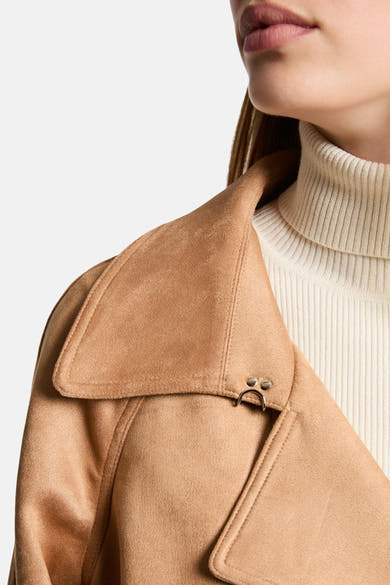 Veste cognac de Morgan de Toi avec col châle et détails métalliques, portée sur un col roulé crème.