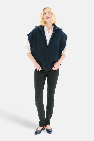 Marineblauwe gewatteerde bodywarmer van CAROLL, gedragen over een wit overhemd met een zwarte broek en platte schoenen.