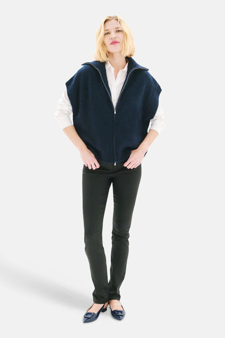 Marineblauwe gewatteerde bodywarmer van CAROLL, gedragen over een wit overhemd met een zwarte broek en platte schoenen.