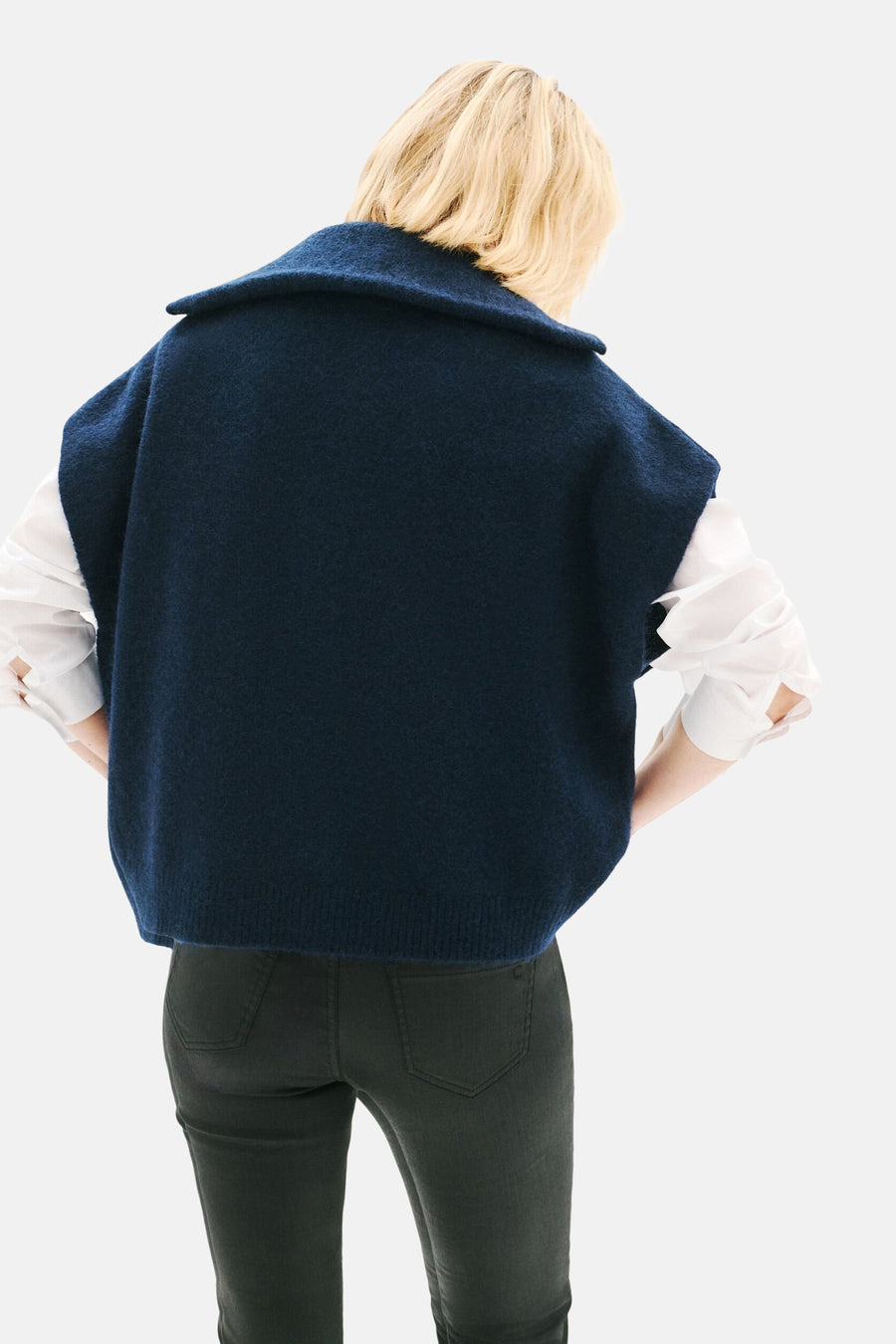 Blauwe CAROLL-gilet, gedragen over een wit overhemd en een donkergroene broek, achterzicht.