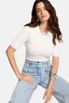 Witte rondehals trui van Morgan de Toi, gedragen met een high-waist jeans met zakken en zilveren sieraden.