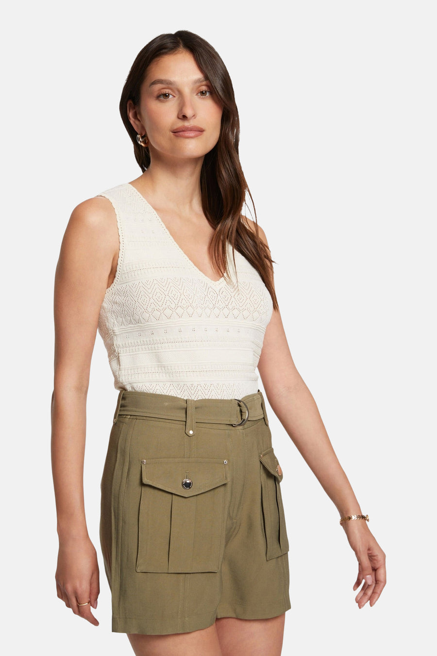 Top écru sans manches de Morgan de Toi, avec une texture crochetée, porté avec un pantalon cargo vert olive.
