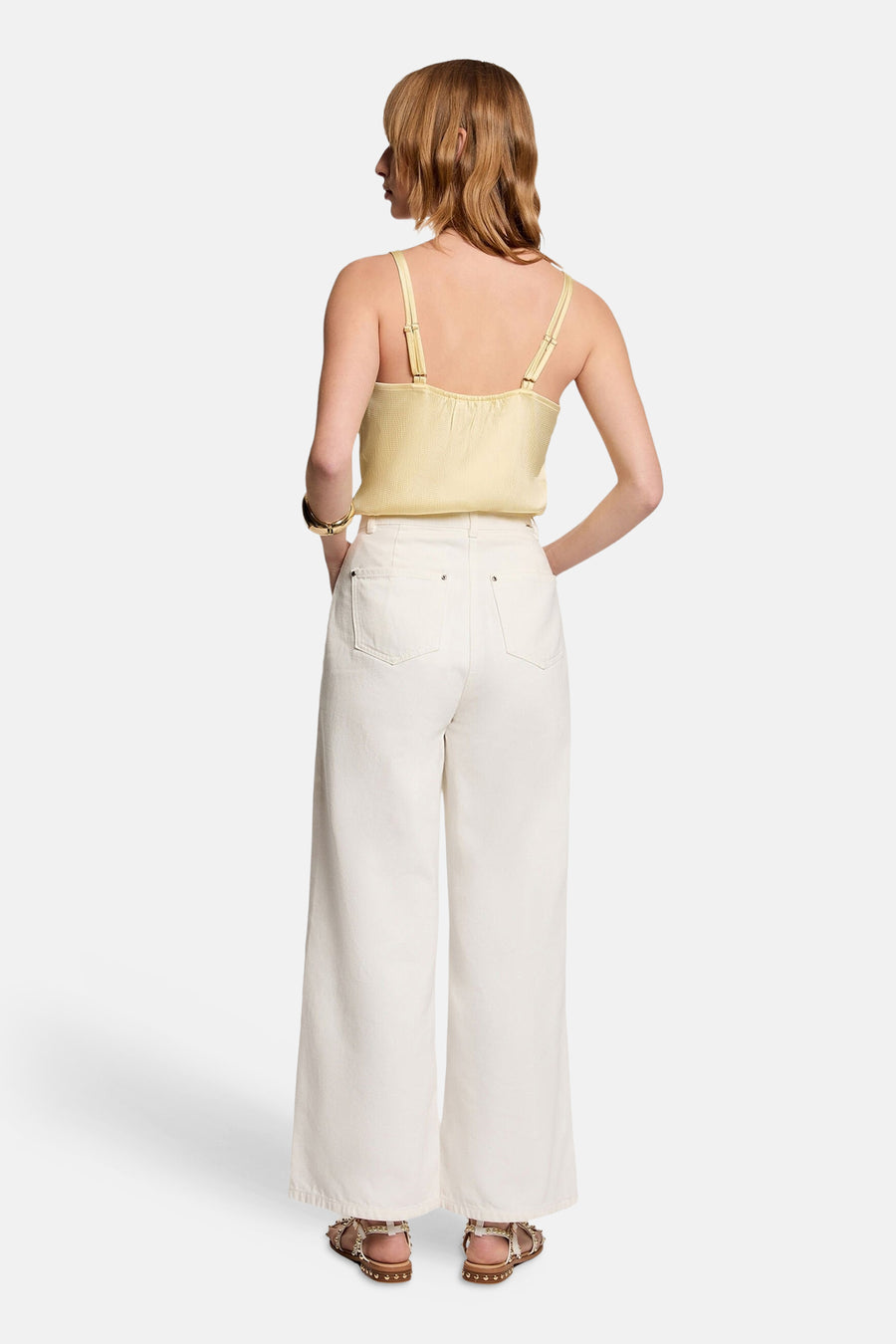 Blouse jaune sans manches de Morgan de Toi avec des bretelles fines et un bracelet doré.