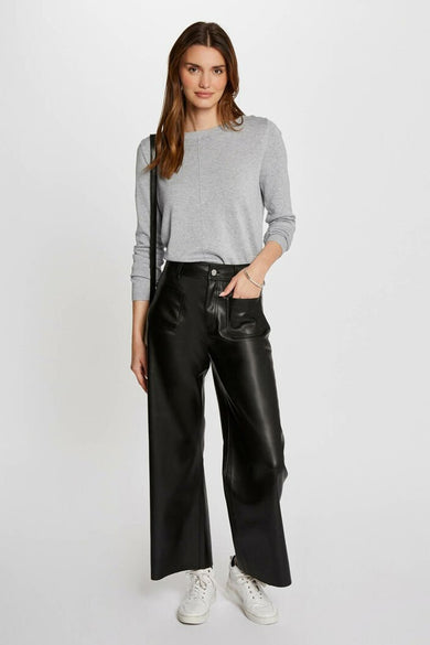 Pantalon coloré noir de Morgan de Toi, large et à poches, porté avec un pull gris et des baskets blanches.