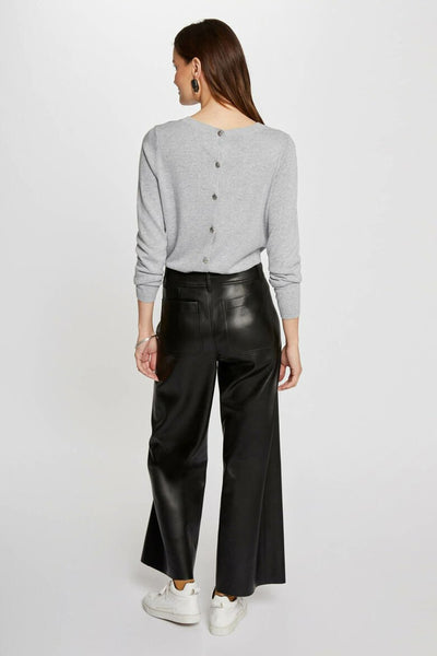 Pantalon coloré noir en similicuir de Morgan de Toi, coupe ample avec poches arrières et portées avec baskets blanches.
