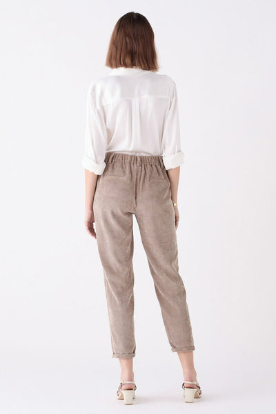 Chino beige de CAROLL, porté avec une chemise blanche et des talons, vue de dos.
