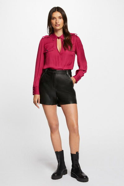 Short noir en cuir par Morgan de Toi, avec détails cloutés et porté avec des bottes noires.
