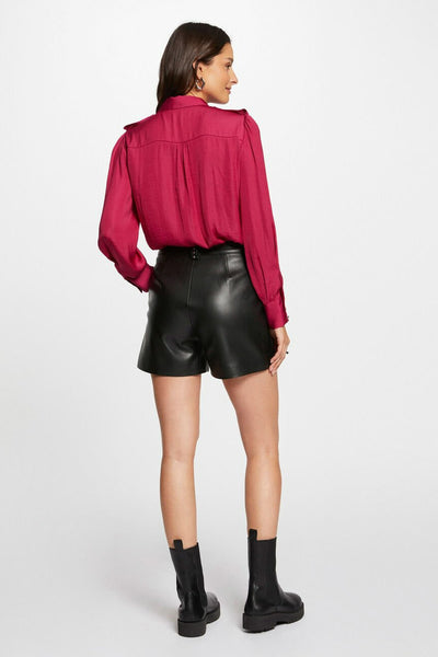 Korte zwarte leren short van Morgan de Toi, gedragen met een fuchsia overhemd en zwarte enkellaarsjes.