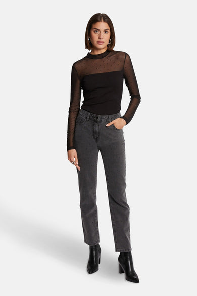 T-shirt à manches longues noir de Morgan de Toi avec manches transparentes à pois, porté avec un jean et des bottines noires.