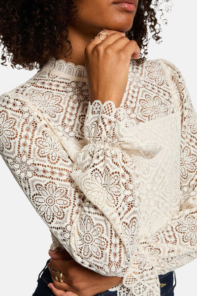 Chemisier à manches longues blanc de Morgan de Toi en dentelle à motifs floraux, avec des manches bouffantes.
