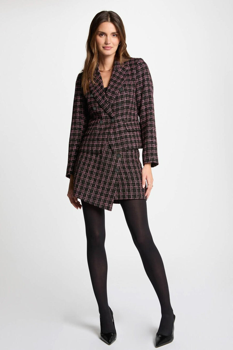Blazer multicolore de Morgan de Toi, à carreaux avec des touches de rose, porté avec une jupe assortie et des collants noirs.