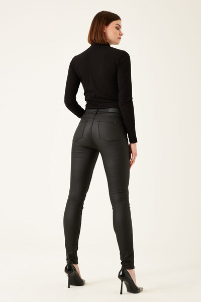 Pantalon coloré noir de GARCIA, porté avec un pull noir à col montant et des talons aiguilles vernis.