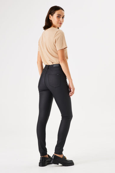 Jean slim zwart van GARCIA, gedragen met een eenvoudig beige t-shirt en dikke zwarte mocassins.
