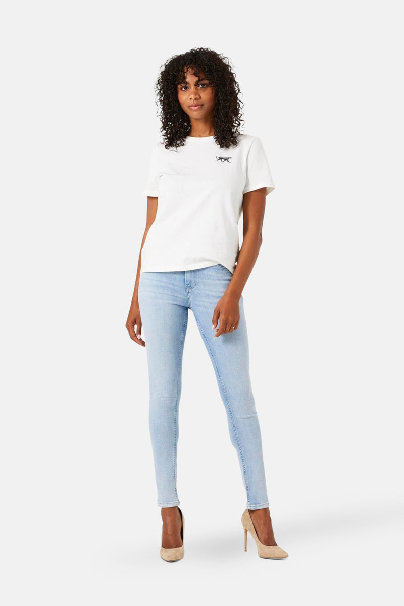 Lichtblauwe spijkerbroek van GARCIA, gedragen met een wit T-shirt en beige pumps.