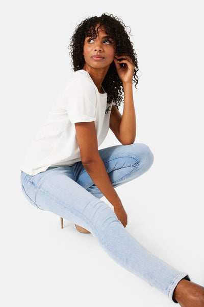 Slim jeans in lichtblauw denim van GARCIA, gedragen met een effen wit T-shirt en nude hakken.