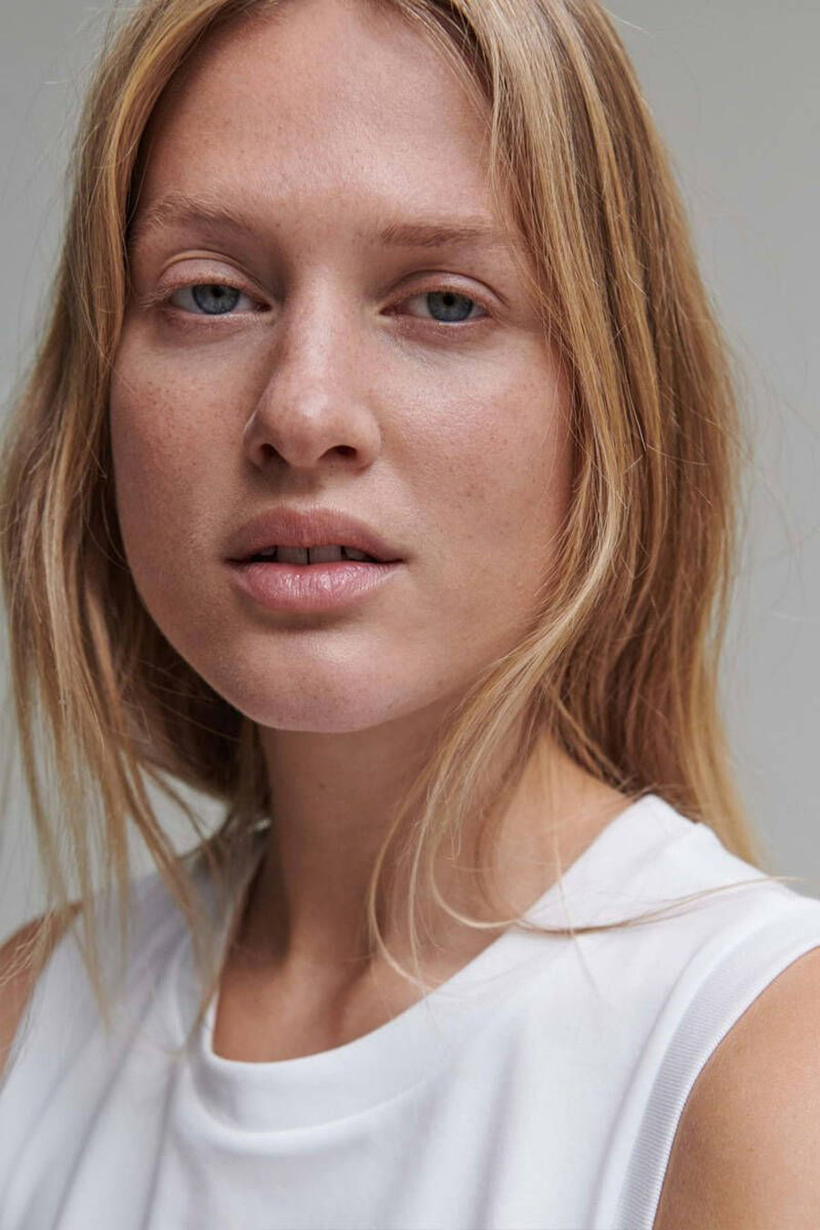 Débardeur blanc d'OPUS, porté par une femme aux cheveux blonds, avec un t-shirt blanc à col ras du cou.