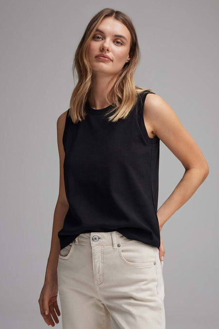 Débardeur noir by OPUS, porté avec un pantalon beige clair, sur fond gris neutre.
