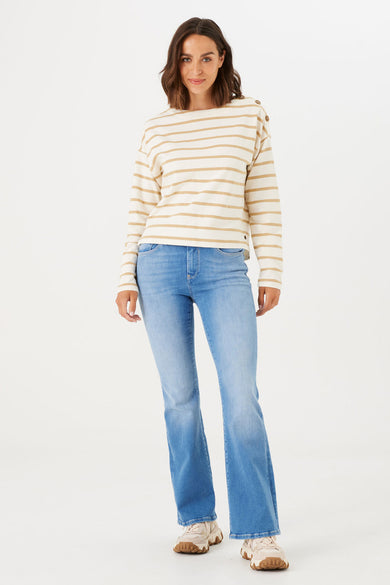 Jean évasé bleu moyen de GARCIA, porté avec un pull rayé beige et blanc.