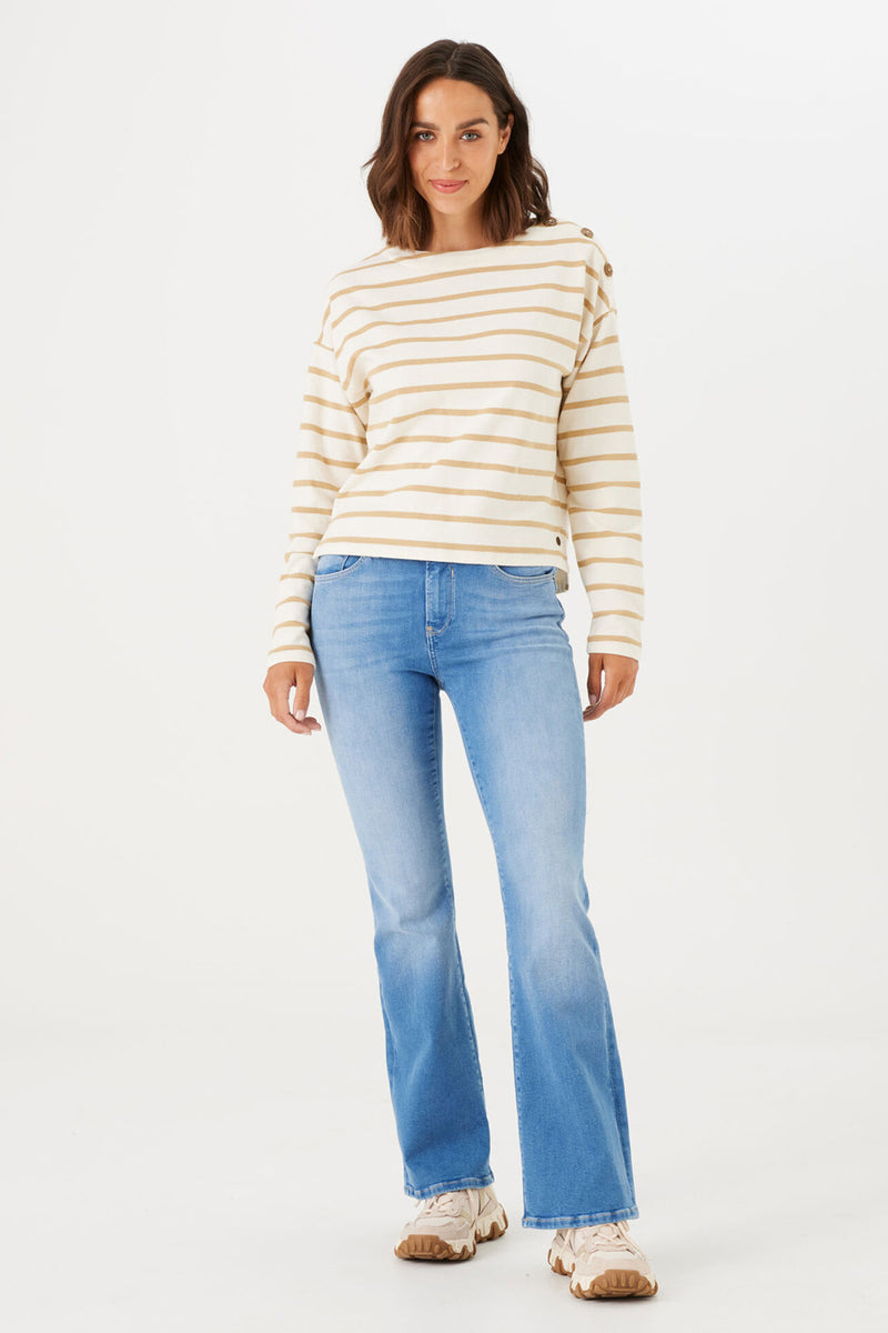 Jean évasé bleu moyen de GARCIA, porté avec un pull rayé beige et blanc.