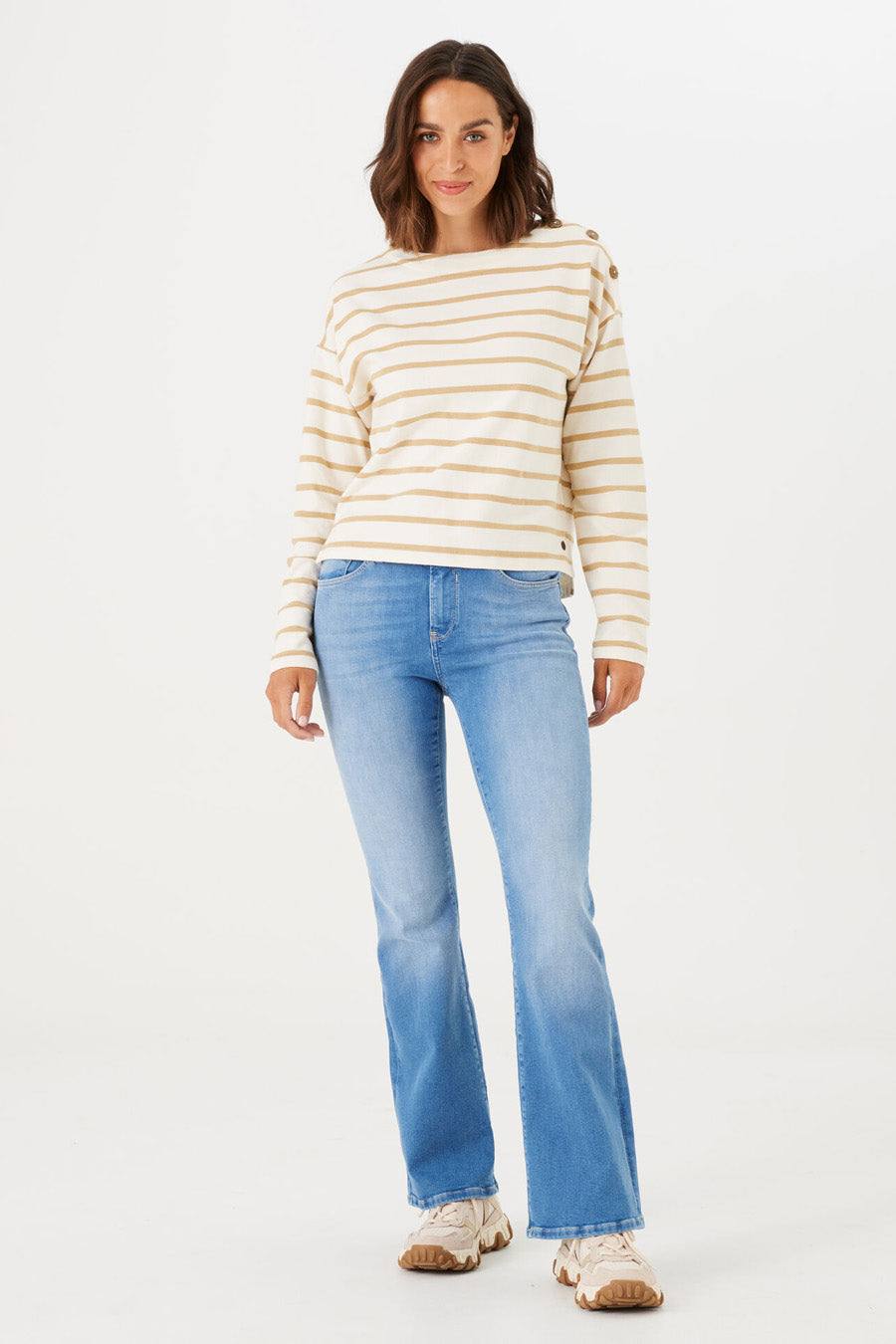Jean évasé bleu moyen de GARCIA, porté avec un pull rayé beige et blanc.