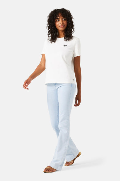 Garcia lichtblauwe bootcut jeans, gedragen met een effen wit T-shirt en gouden sandalen.