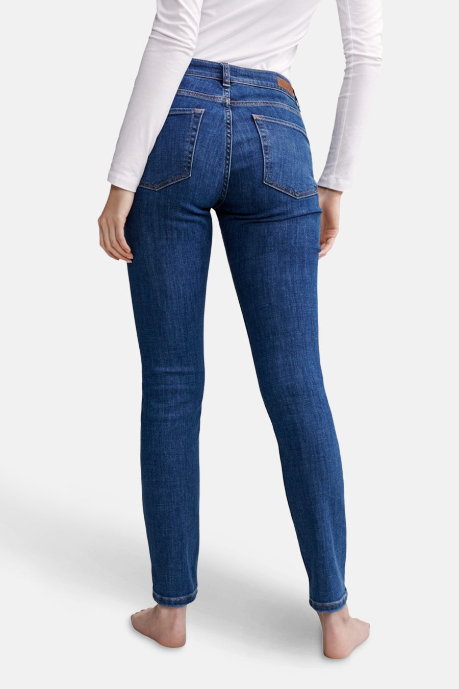 Jeans skinny en denim bleu moyen d'OPUS, avec poches arrière et coupe droite, portés avec un haut blanc à manches longues.