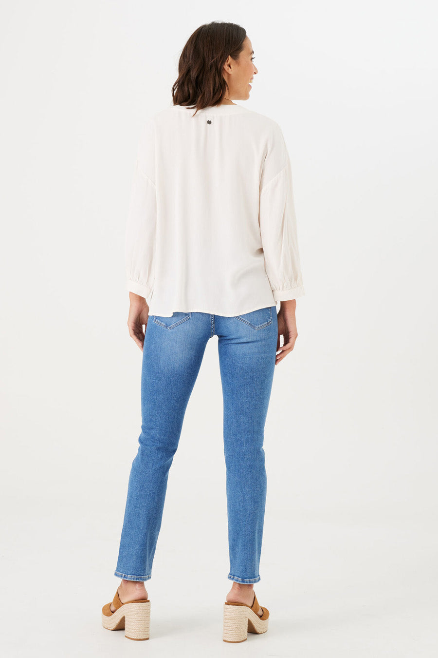 Rechte spijkerbroek in middinblauw denim van GARCIA, achteraanzicht, gedragen met een gebroken witte top en sleehakken.