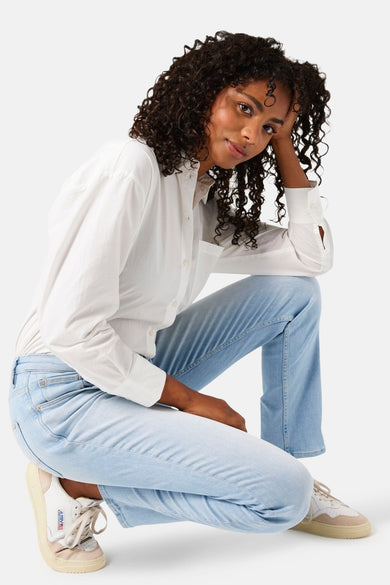 Jean in lichte blauwe denim van GARCIA, gedragen met een witte shirt en sneakers.