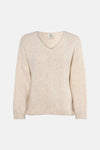 Ecru V-hals trui van Terra di Siena, gedragen met een blauwe jeans en nude pumps.