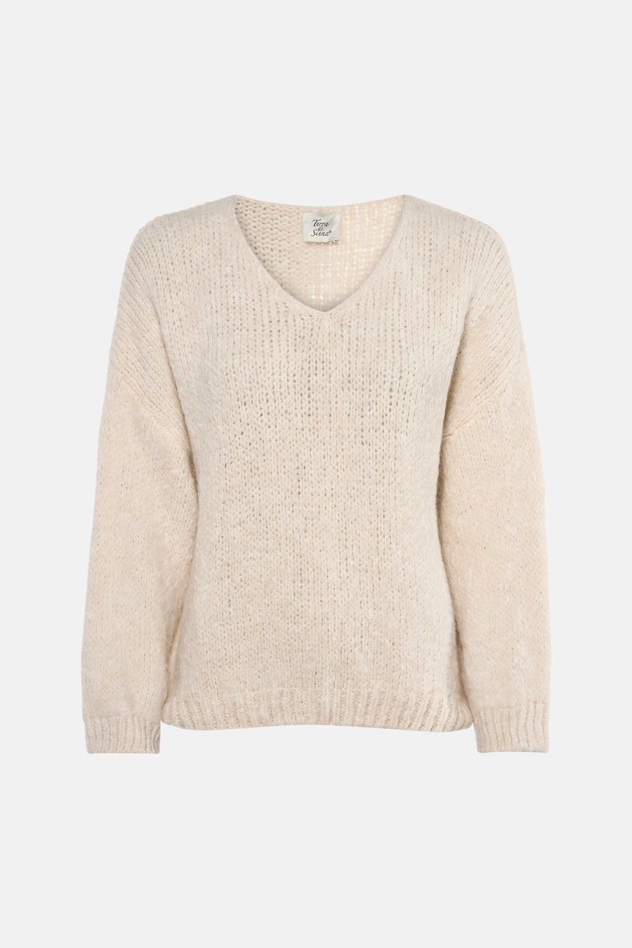 Ecru V-hals trui van Terra di Siena, gedragen met een blauwe jeans en nude pumps.