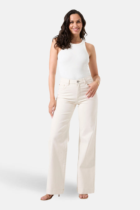 Jean large en denim blanc cassé de Garcia, porté avec un haut blanc et des chaussures à talons.
