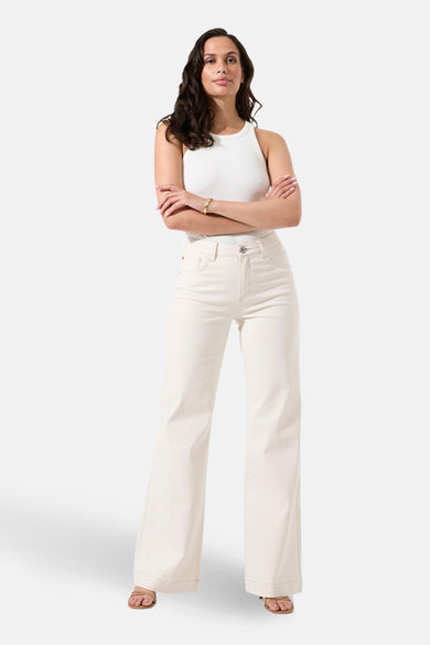 Jean large en denim blanc cassé de Garcia, porté avec un haut sans manches et des sandales.