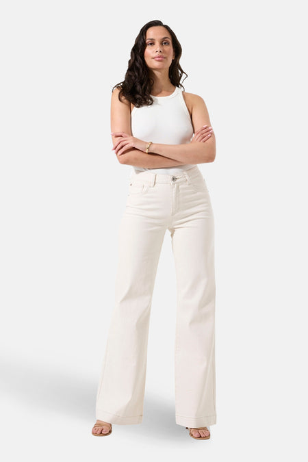 Jean large en denim blanc cassé de Garcia, porté avec un haut sans manches et des sandales.