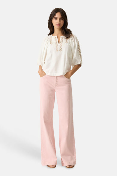 Jean large rose de GARCIA, porté avec un chemisier blanc à broderies décoratives.