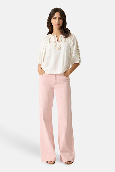 Jean large rose de GARCIA, porté avec un chemisier blanc à broderies décoratives.
