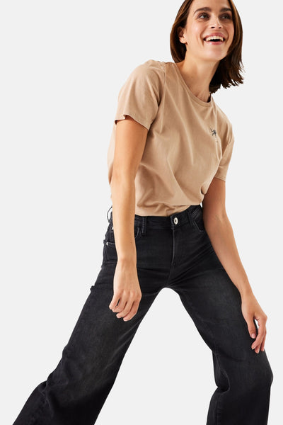 Jean large en denim noir de GARCIA, porté avec un t-shirt marron clair.