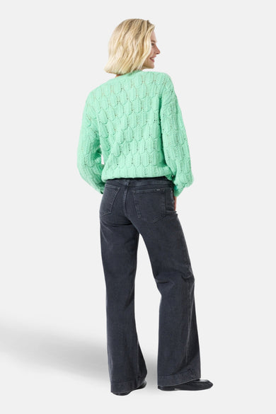 Jean large en denim noir de GARCIA, porté avec un pull en maille vert d'eau.