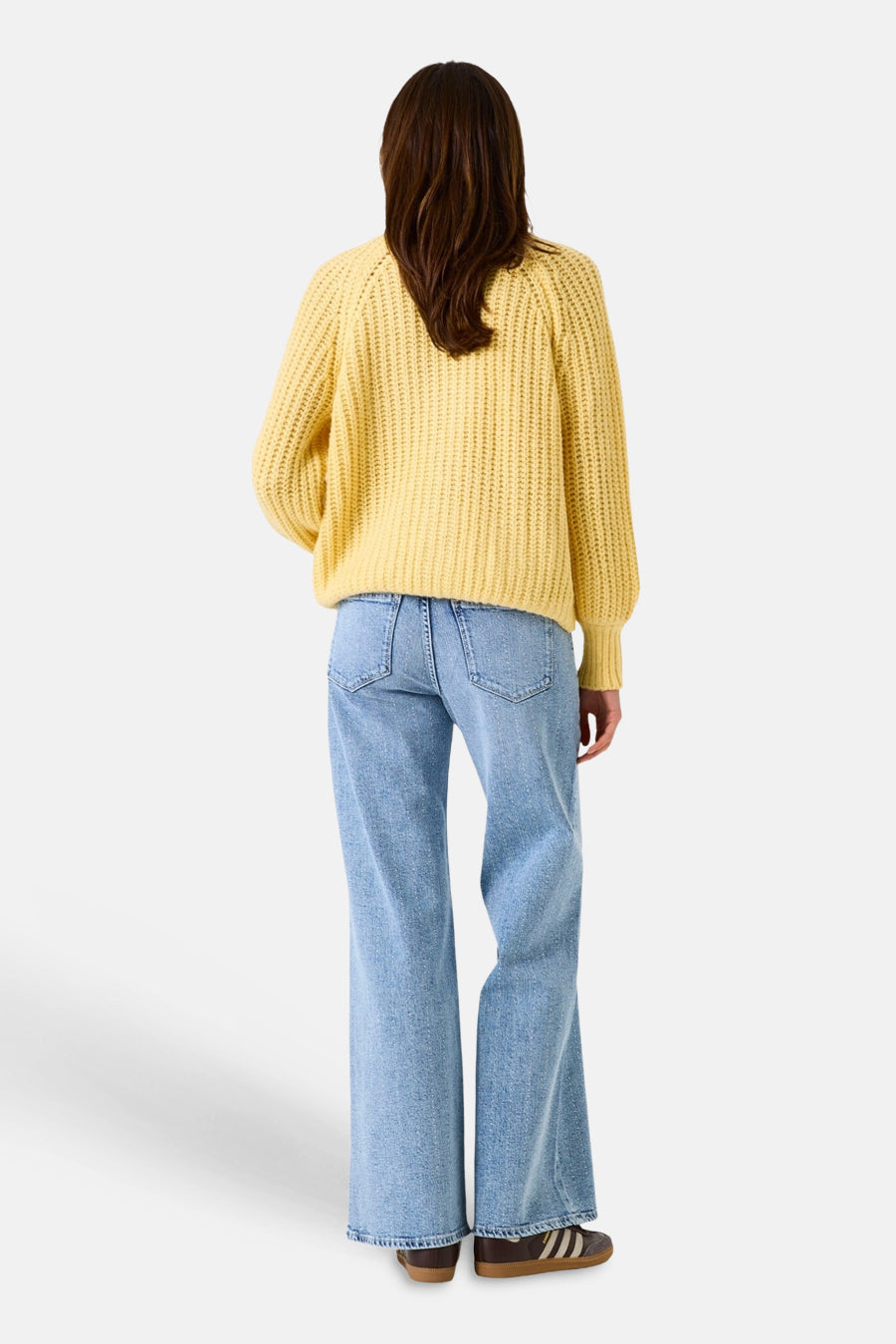 Jean large en denim bleu clair de GARCIA, vu de dos, porté avec un pull jaune épais et des baskets marron.