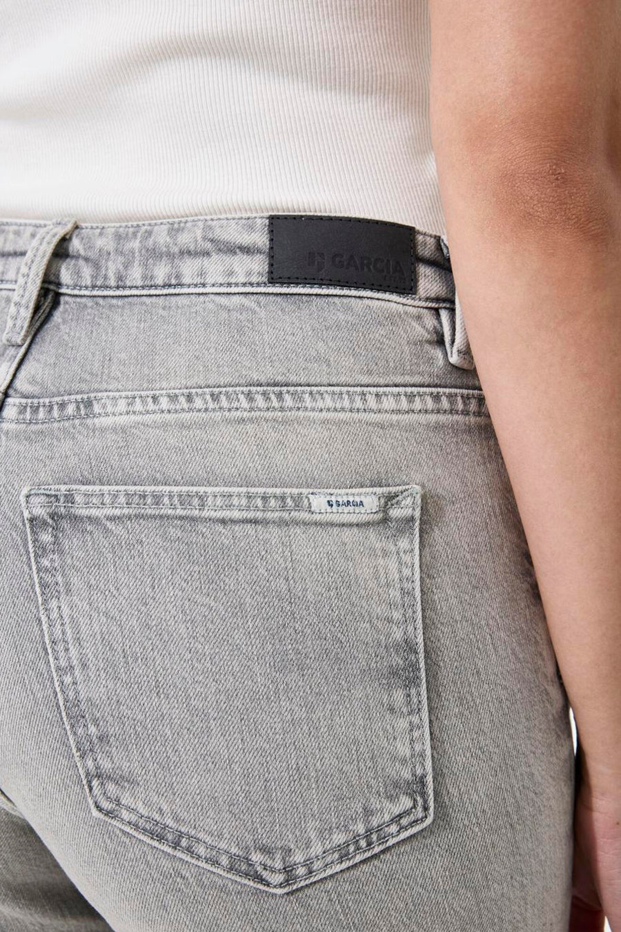 Lichtgrijze wijde jeans van GARCIA, achterzakdetail met logo en leren label op de tailleband.