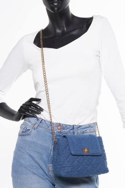 Blauwe denim schoudertas van Morgan de Toi met gouden ketting, gedragen met een wit T-shirt en een spijkerbroek.