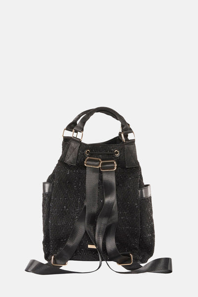 Sac à main noir par Morgan de Toi avec des bretelles, et une texture brillante.